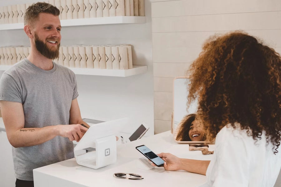 Équipe commerciale analysant une stratégie de fidélisation client, sourires et engagement autour d'un tableau de bord digital