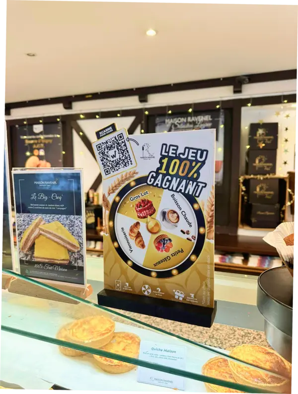 Chevalet du jeu 100% gagnant Maison Ravenel avec QR code posé sur la vitrine de la boulangerie