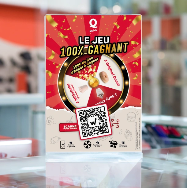 Flyer plastifié du jeu concours Quick « Le jeu 100 % gagnant » avec roue à cadeaux et QR code sur un comptoir