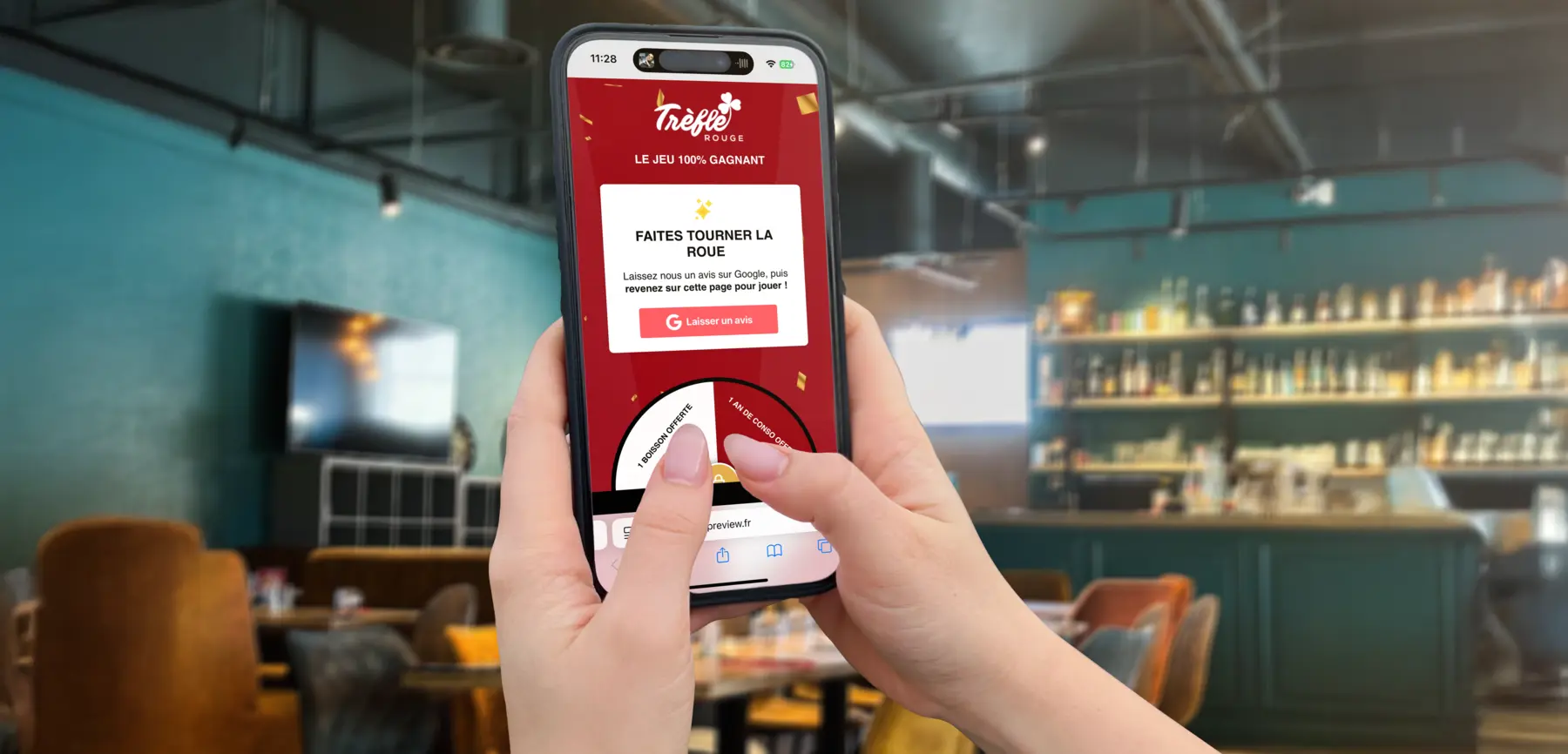 Smartphone en main affichant la roue à cadeaux du jeu concours Trèfle Rouge dans la salle du bar à jeux